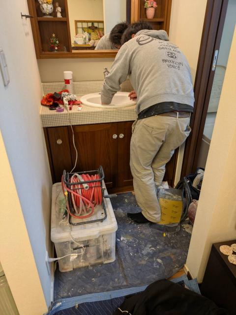 品川区小山でスタッフが洗面ボウルを綺麗に磨いている写真