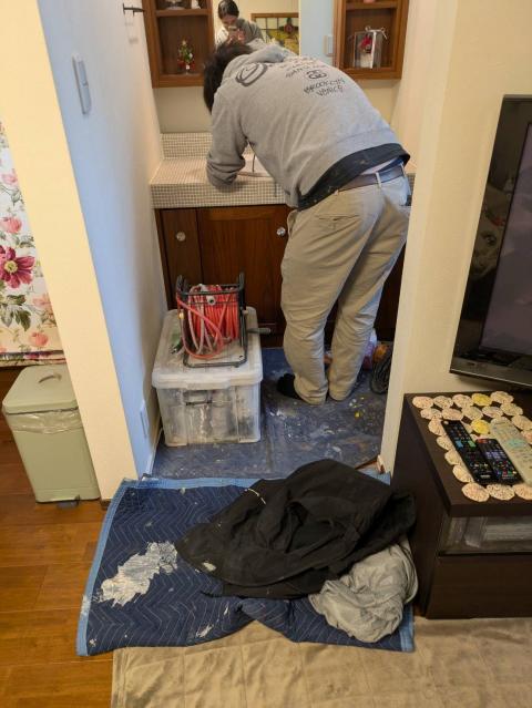 品川区小山で洗面ボウルの汚れをスタッフが落としている写真