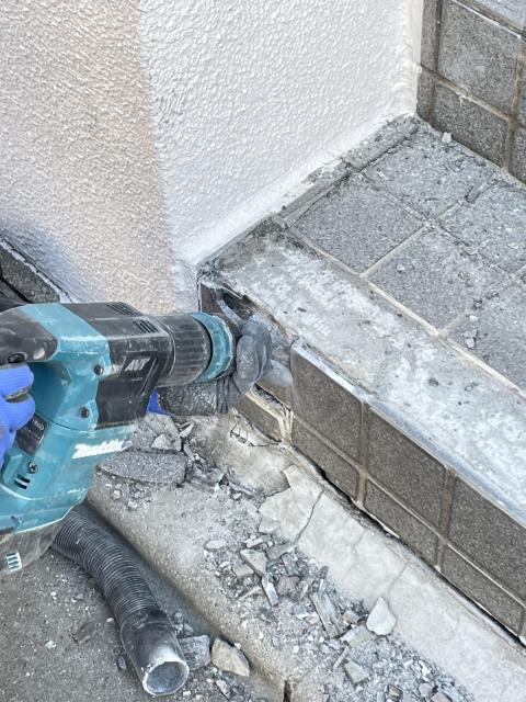 武蔵小山のマンションエントランスの階段一段目の蹴上タイル部分を壊している写真