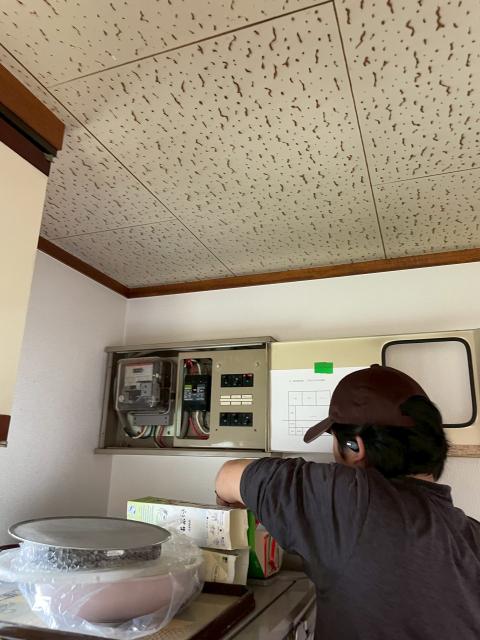 品川区旗の台の家でエアコン設置調査のためブレーカーを見ている作業員の写真