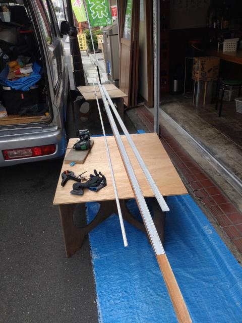 品川区西小山の居酒屋さんの入り口扉の木製の枠の変形を削っている写真