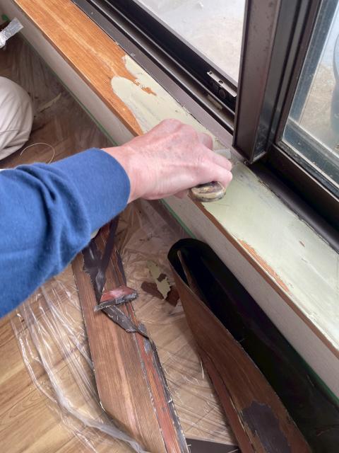 武蔵小山で経年劣化した掃き出し窓枠を研磨しプライマー塗布している写真