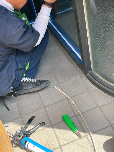 品川区戸越銀座の居酒屋さん　ガラスをはめてコーキングをしている写真