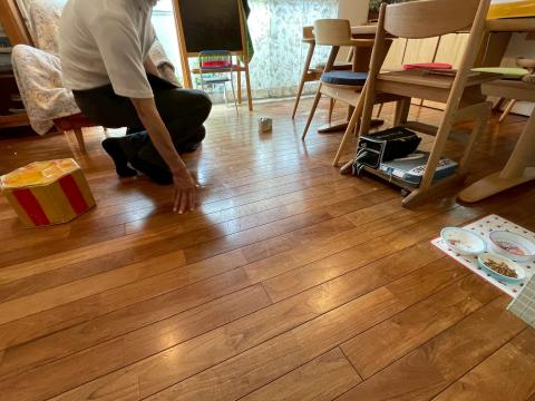 品川区小山台で床フローリングの劣化による変色を調査する作業員の写真
