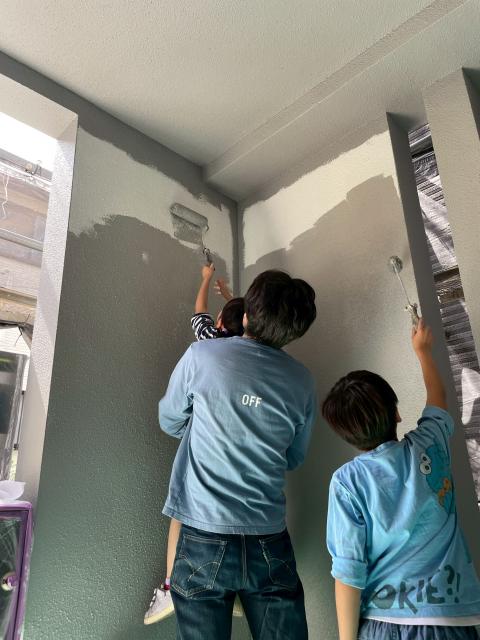 品川区武蔵小山で外壁塗装改修工事の終盤にお父様が抱えてお子様たちが塗装している写真