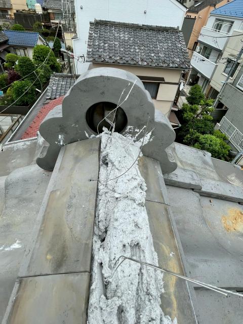 目黒区目黒本町で屋根瓦の修繕工事で漆喰を詰め直している写真