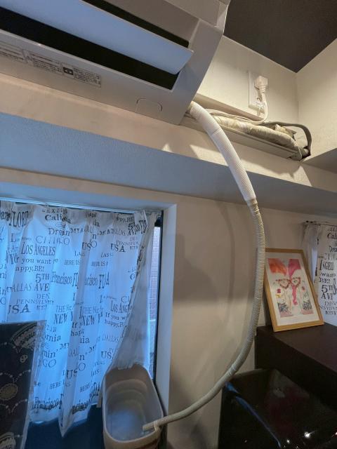 品川区平塚でエアコン水漏れの調査ドレンホースから溜まった水を出している写真