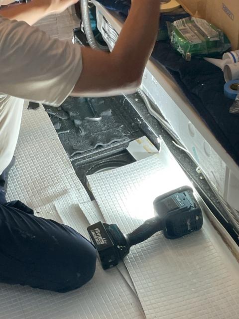 品川区戸越で浴室ユニットバスの床スタッフが補修している写真