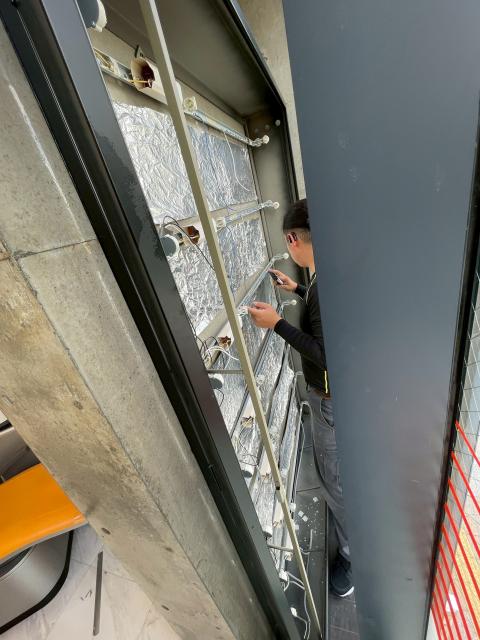 武蔵小山駅前の歯科で看板照明工事をスタッフが行っている写真