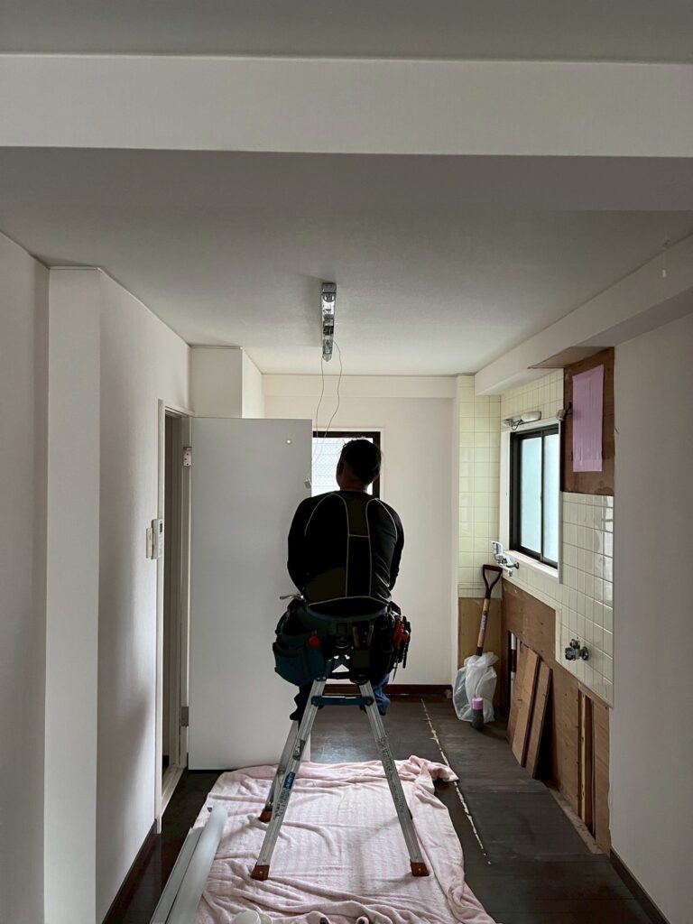 武蔵小山賃貸マンションで職人が天井の蛍光灯を確認している写真