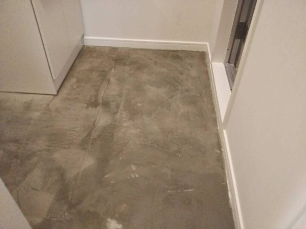 武蔵小山の賃貸マンションで洗面所の床を剥がして下地調整をしている写真