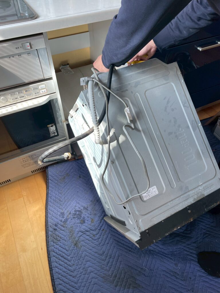 品川区荏原で作業員が食洗機を撤去している写真