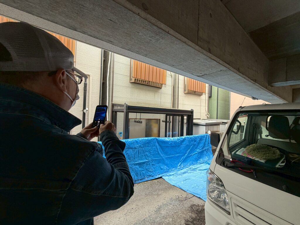 品川区平塚で作業員が既存サンルームを撮っている写真
