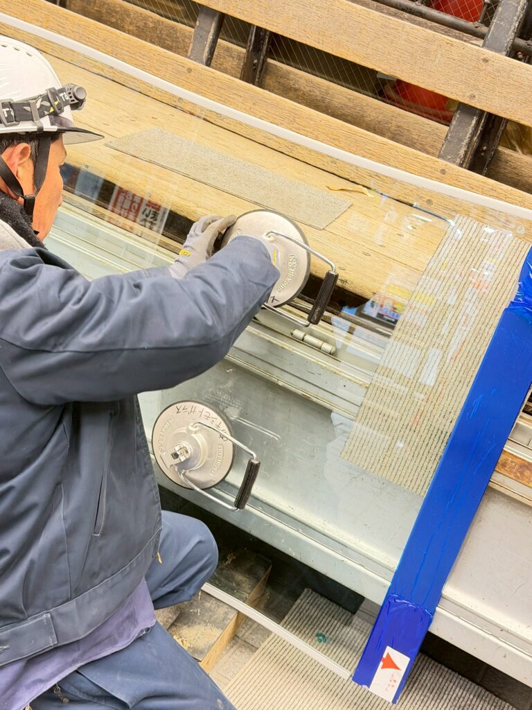 大型テナントビルさん割れたガラスドア交換のガラスを運ぶ写真