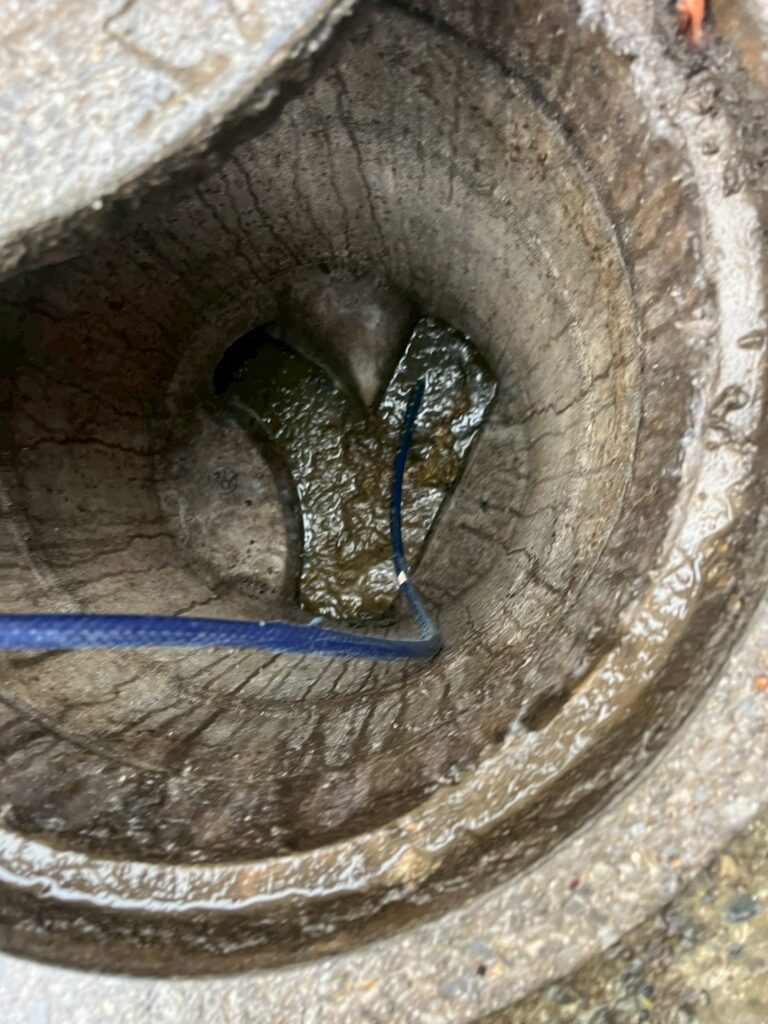 目黒区下目黒で戸建て汚水桝の中を洗浄している写真