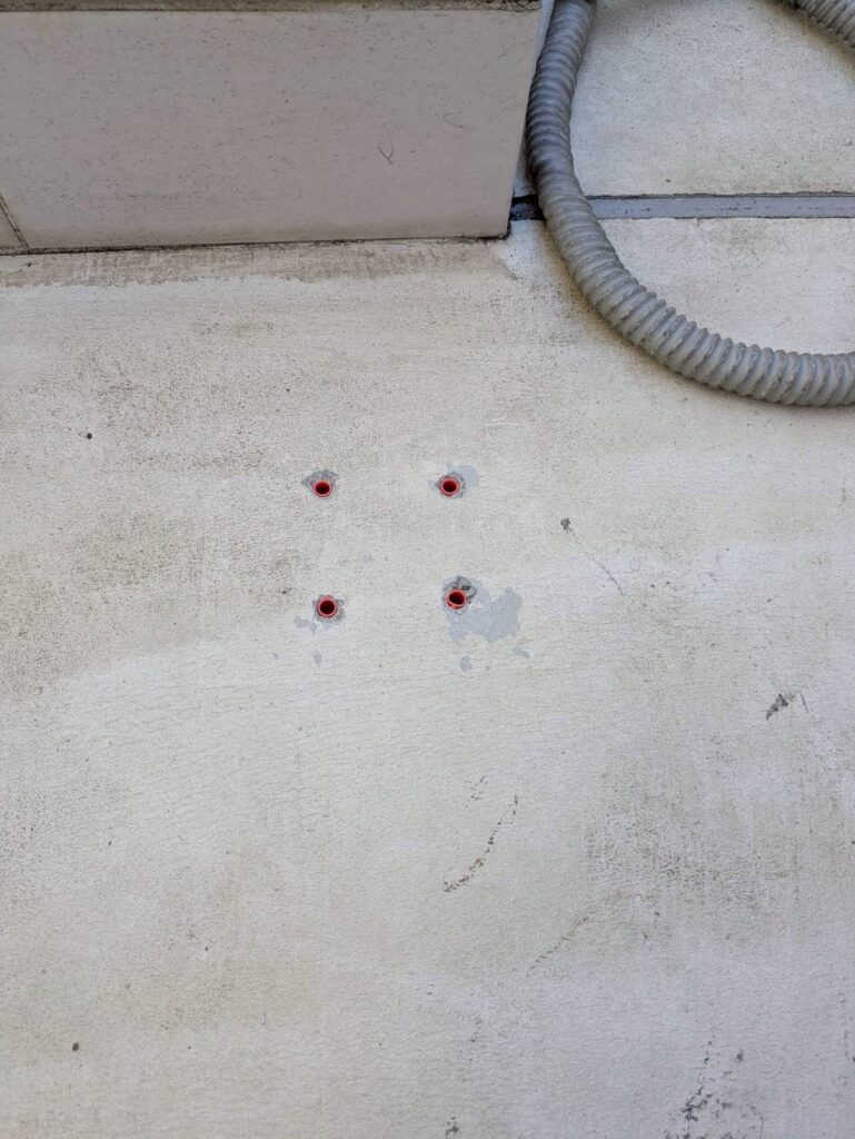 目黒本町のアパート踊り場手すりでハンマードリルの後テープを剥がした写真