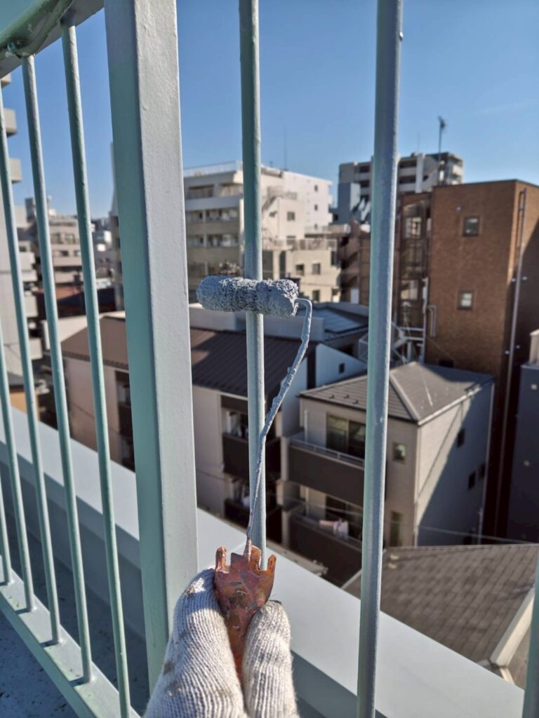 品川区西五反田でローラーで鉄部手すりのサビ止め塗装をしている写真