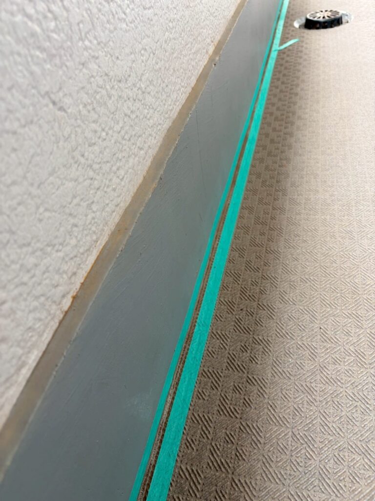 長尺シートの貼ったところの廊下のシール打ち替え養生テープの写真