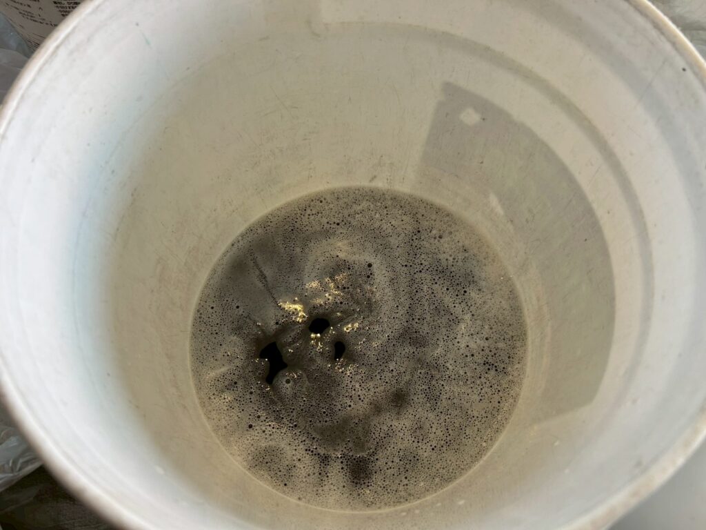 品川区荏原でオフィスエアコン高圧洗浄後の汚水写真