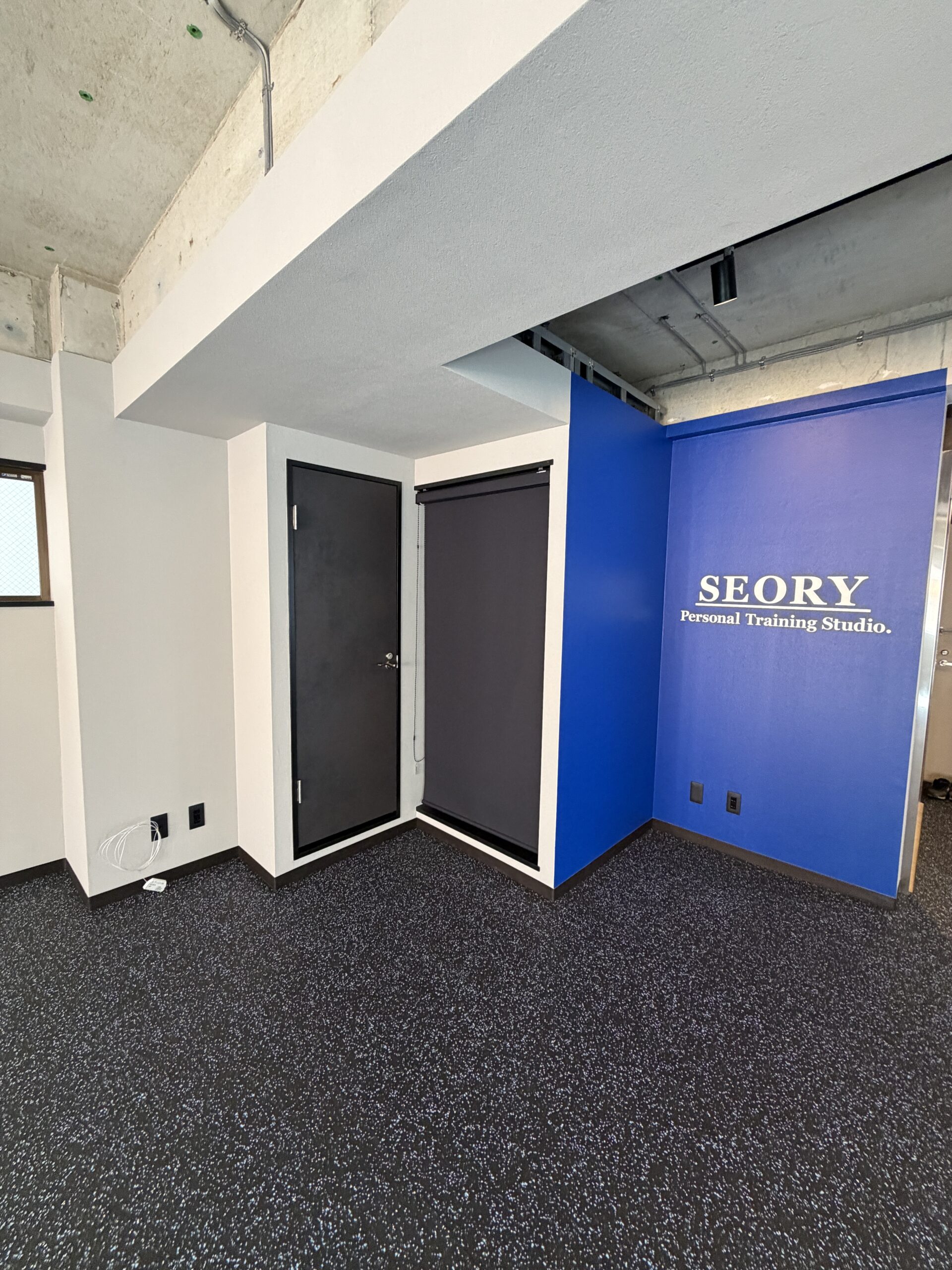 品川区五反田のジムトイレドアと青いサイン壁ラバー床の写真