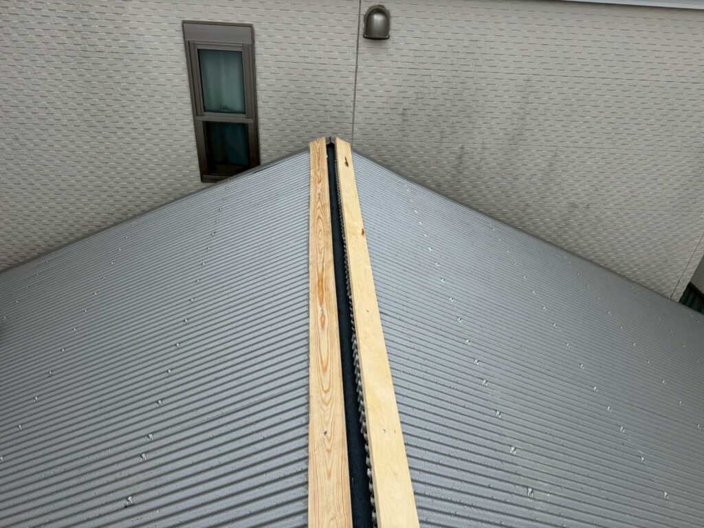目黒本町で下地もくざいをビスで止めし終え金属カバーを被せていく直線の写真