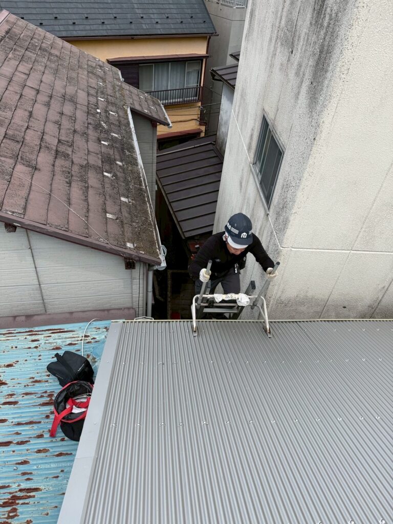 、目黒区目黒本町でスタッフが梯子を上る写真