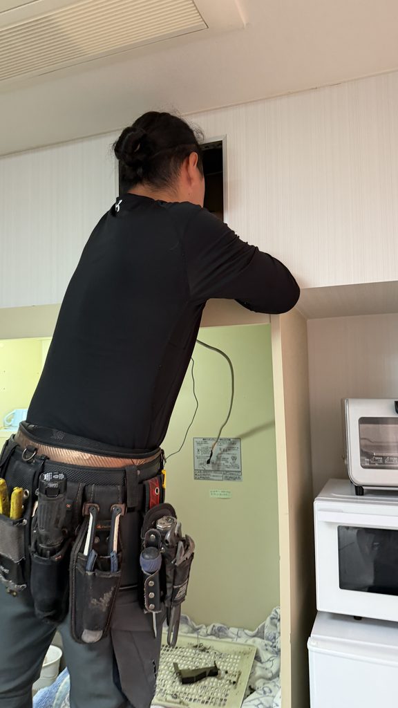 目黒区洗足で換気扇の点検港を覗いているスタッフ写真