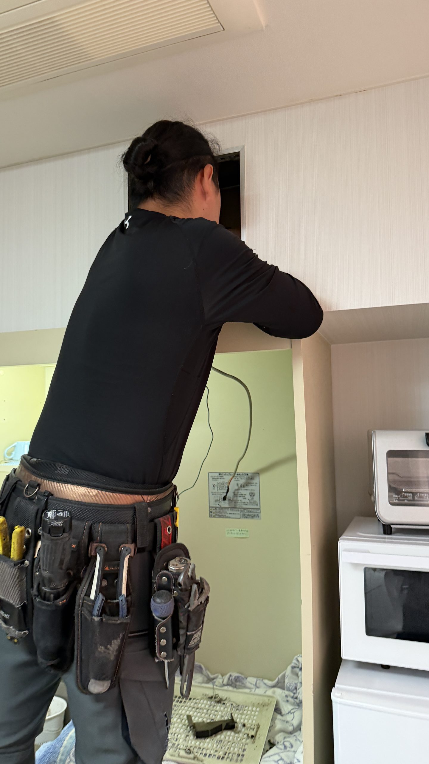 目黒区洗足で天井点検口から換気扇確認していっる写真