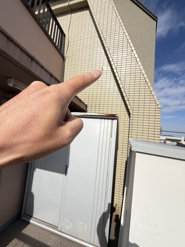 武蔵小山でマンションオーナー様から外壁タイルの剥がれの相談指で刺している写真