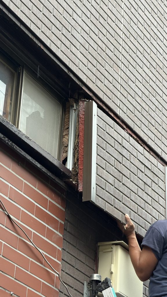 目黒区洗足で外壁が落っこちそうでスタッフが取り外している写真